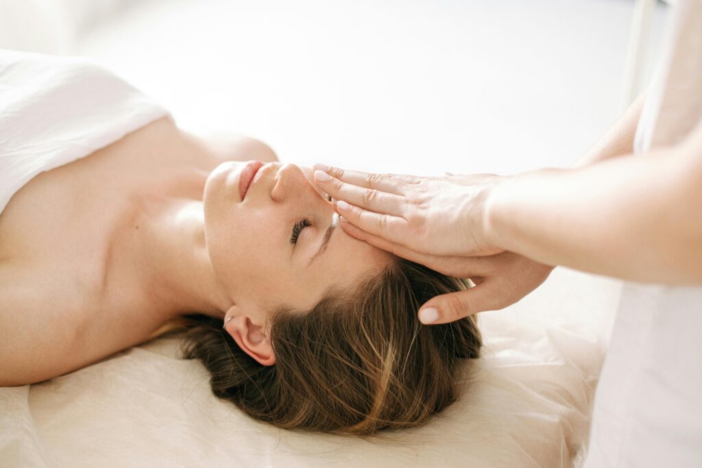 Woman enjoying a peaceful head massage in a serene spa environment.