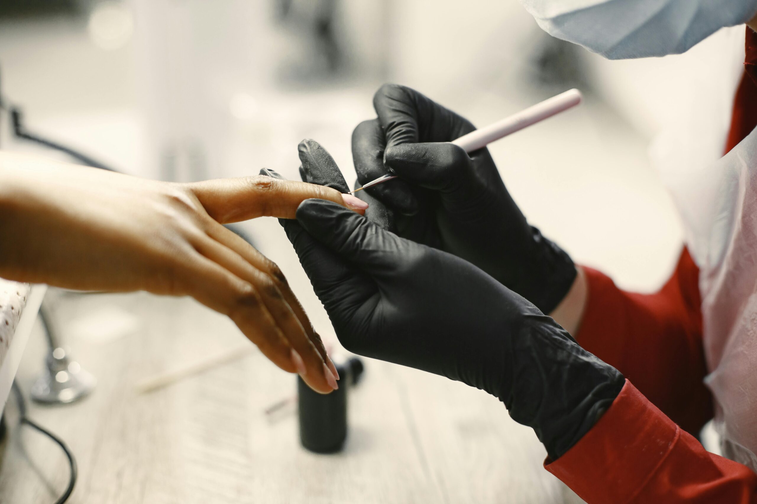 Close-up of a professional manicure session with tools and black gloves in a modern salon.